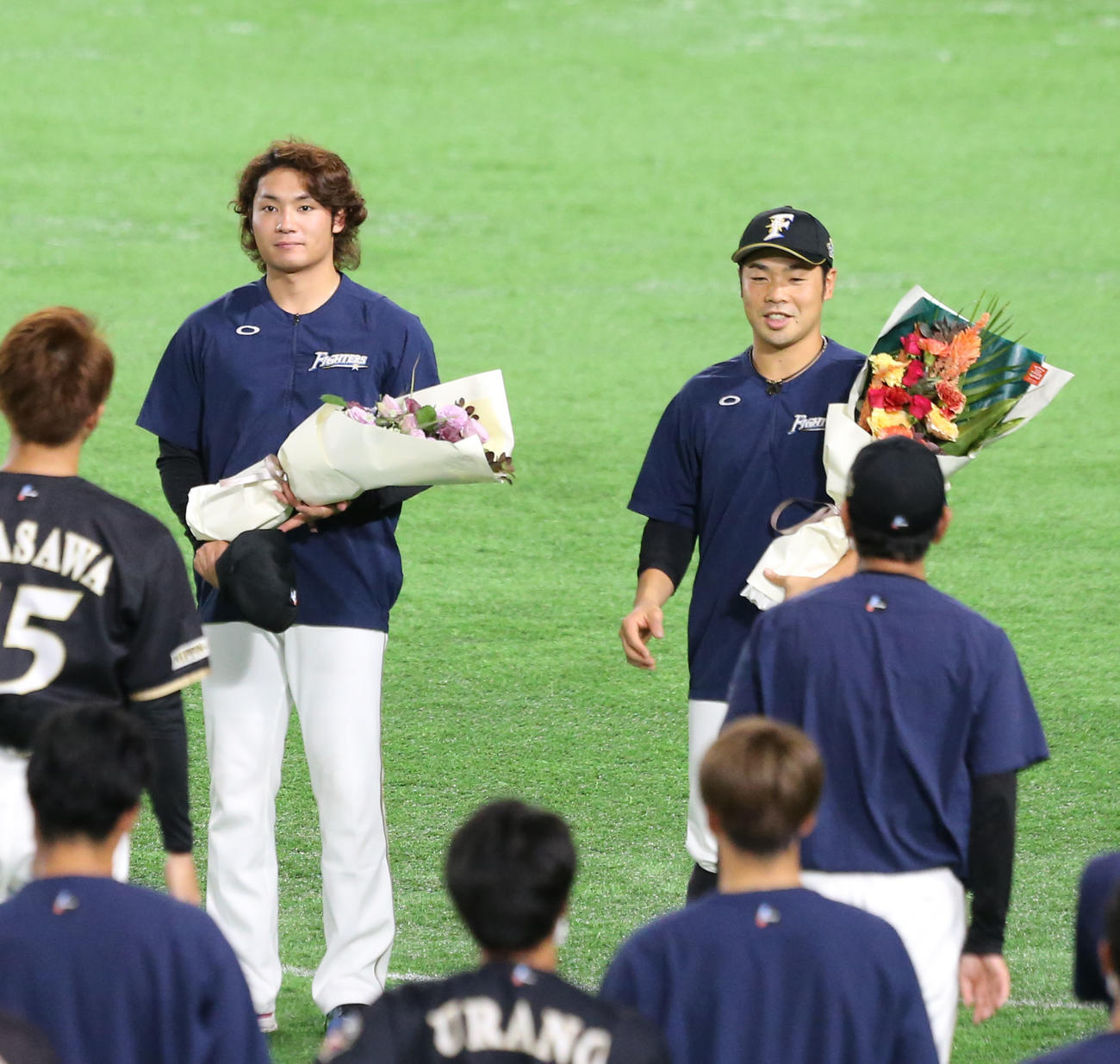 チームから花束をもらう日本ハム伊藤（左）と近藤（右）（撮影・屋方直哉）