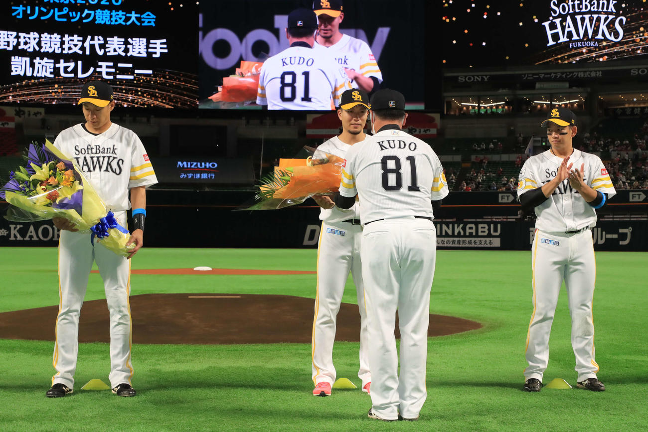 東京五輪凱旋（がいせん）セレモニーで工藤監督から花束を受け取るソフトバンク千賀。左は柳田、右は栗原（球団提供）