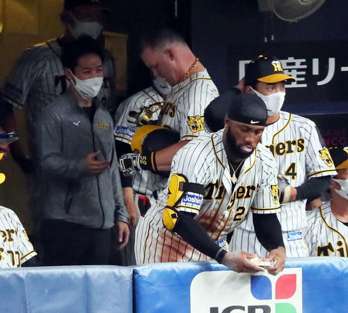 阪神対広島 4回裏阪神2死一、二塁、サンズは左越え3点本塁打を放ち、金メダルを受け取が、丸い部分が落下する(撮影・宮崎幸一)