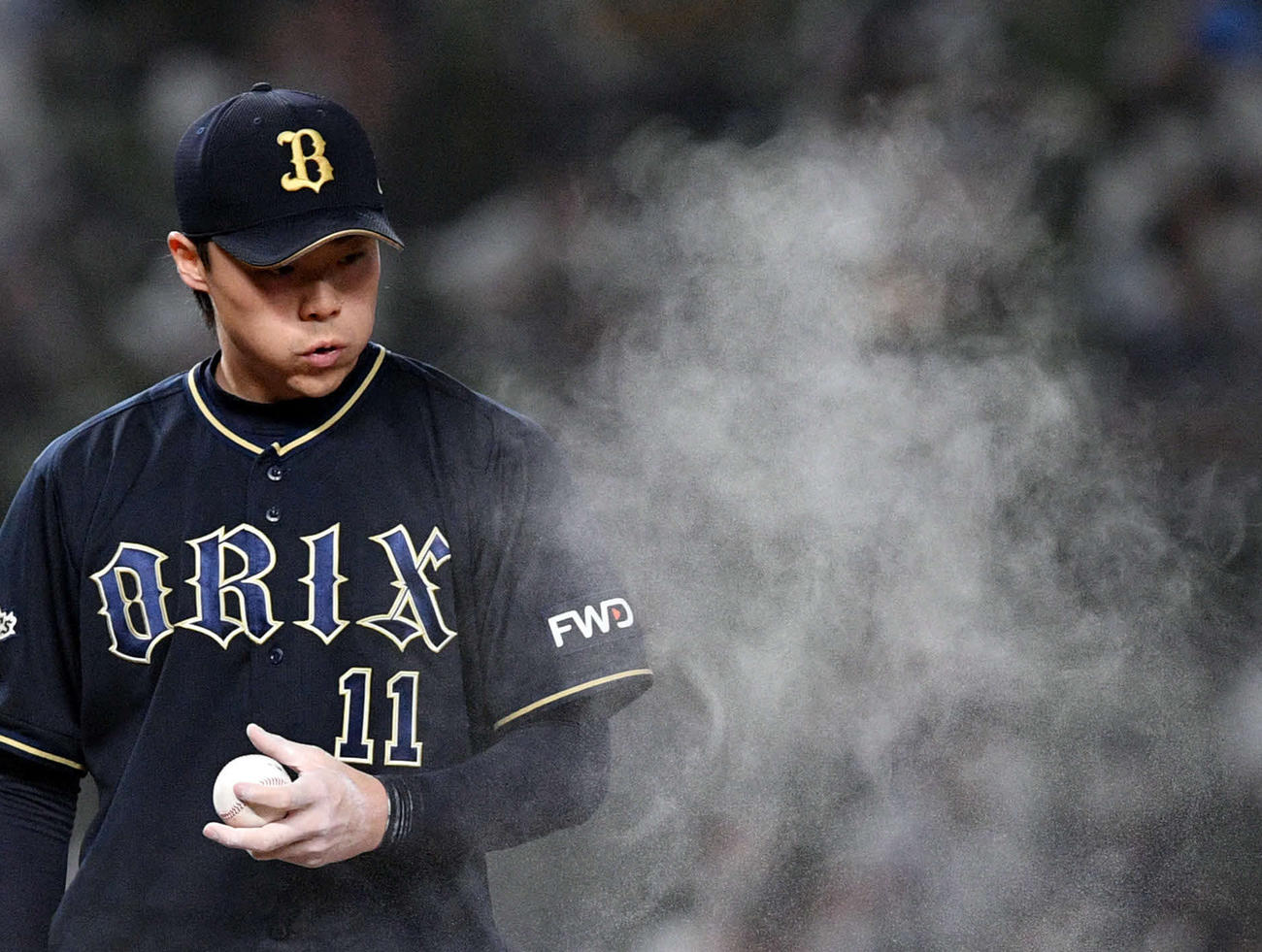 西武対オリックス　舞い上がったロジンの粉に息を吹くオリックス先発の山崎福（撮影・滝沢徹郎）