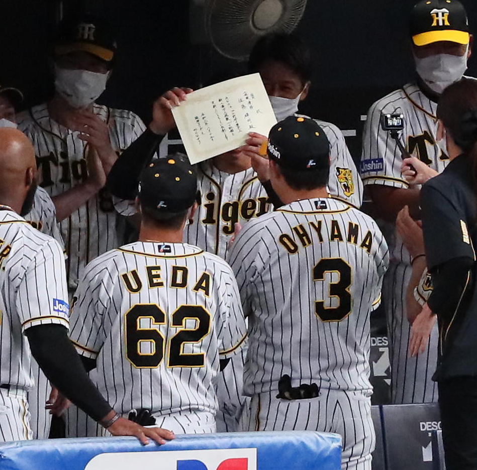 試合前円陣で、新人の最多三振記録達成を手書きの表彰状で祝福された佐藤輝（撮影・宮崎幸一）