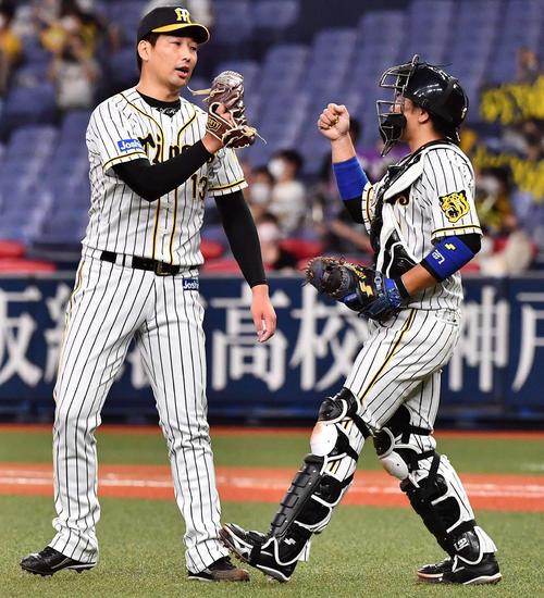 阪神対広島　9回表を無失点に抑え梅野（右）とグラブタッチして喜ぶ岩崎（撮影・上田博志）