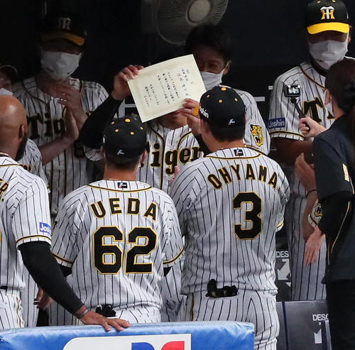 試合前円陣で、新人の最多三振記録達成を手書きの表彰状で祝福された佐藤輝（撮影・宮崎幸一）