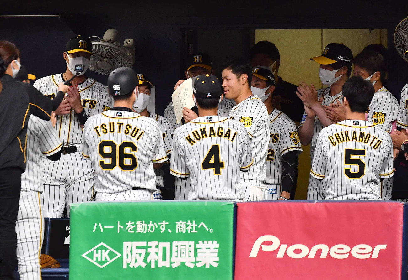 阪神対広島　佐藤輝（中央）は試合前の円陣で坂本から賞状をもらい笑顔を見せる（撮影・上田博志）
