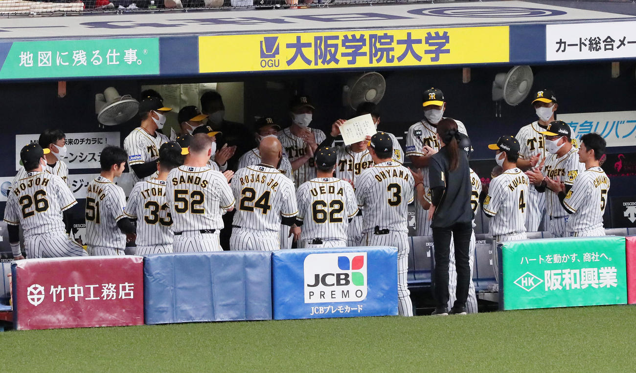 阪神対広島　試合前円陣で、新人三振記録達成を手書きの表彰状で祝福された佐藤輝（撮影・宮崎幸一）
