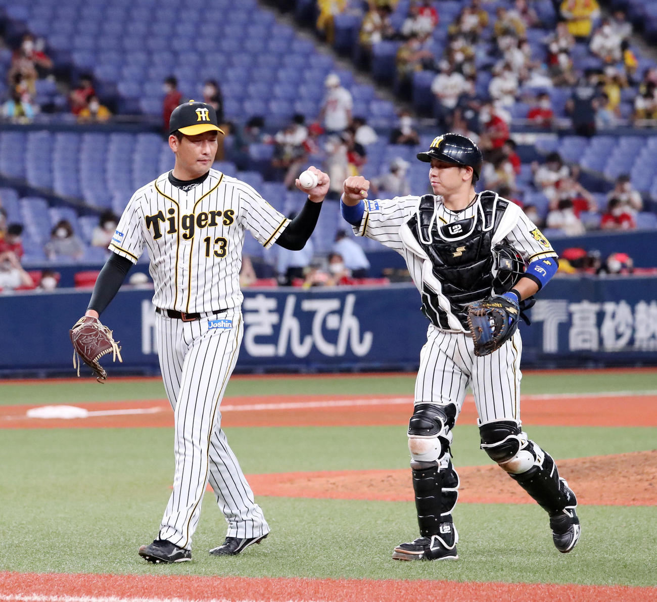 阪神対広島　セーブを記録した岩崎（左）は梅野と肘タッチする（撮影・加藤哉）
