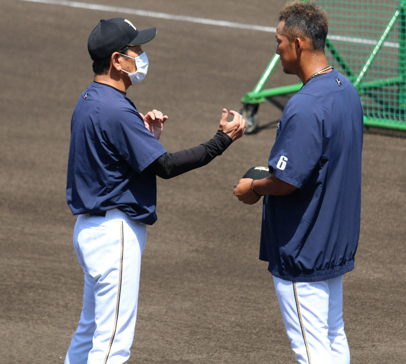 7月、千葉・鎌ケ谷の2軍施設で全体練習に参加した中田（右）と話す栗山監督