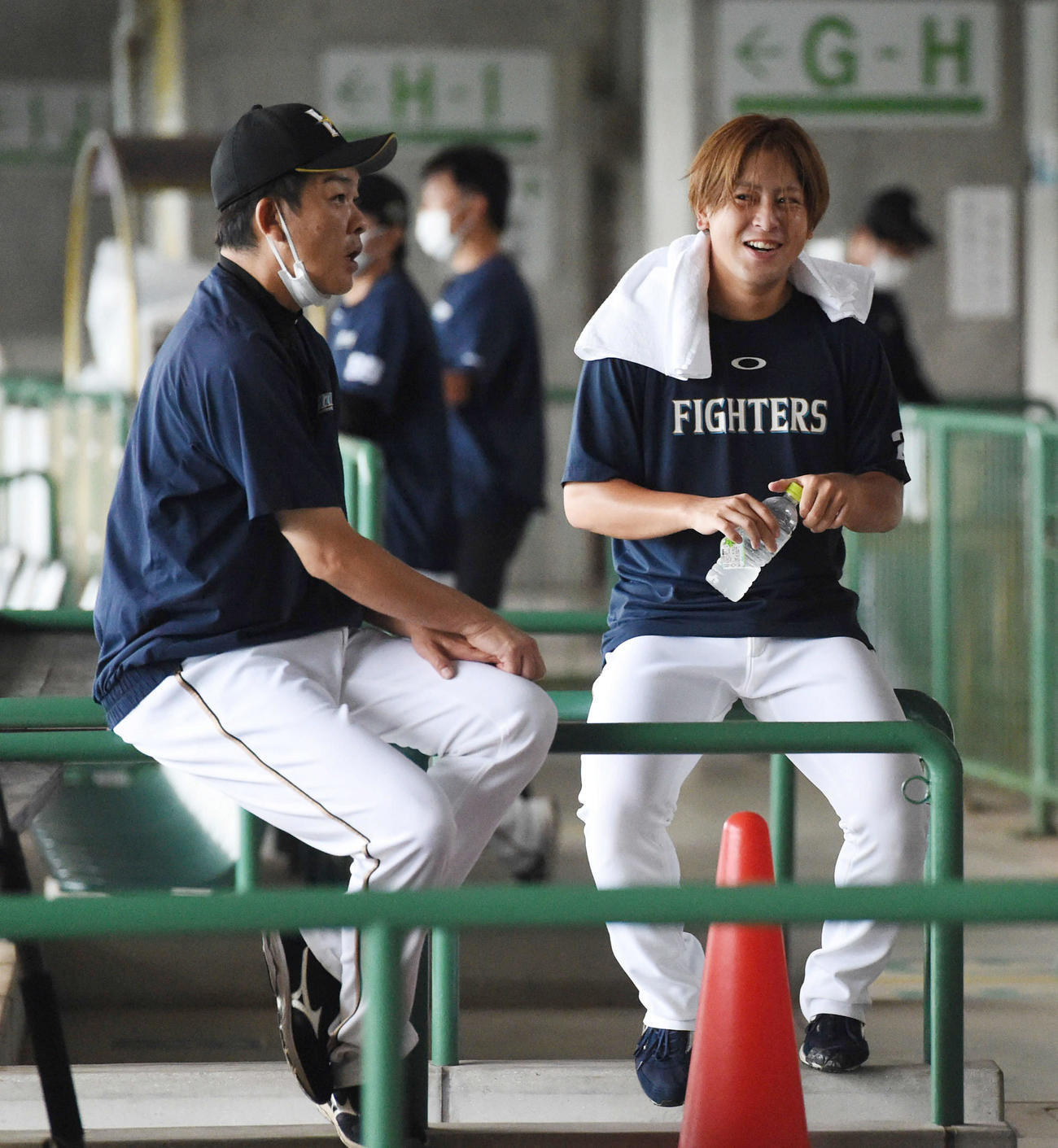 練習で笑顔を見せる日本ハム河野（右）。左は厚沢コーチ（撮影・前岡正明）