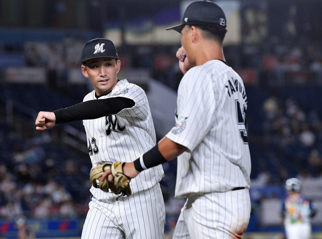 ロッテ対西武　6回表を投げ終えたロッテ小島（左）は山口とタッチを交わす（撮影・滝沢徹郎）