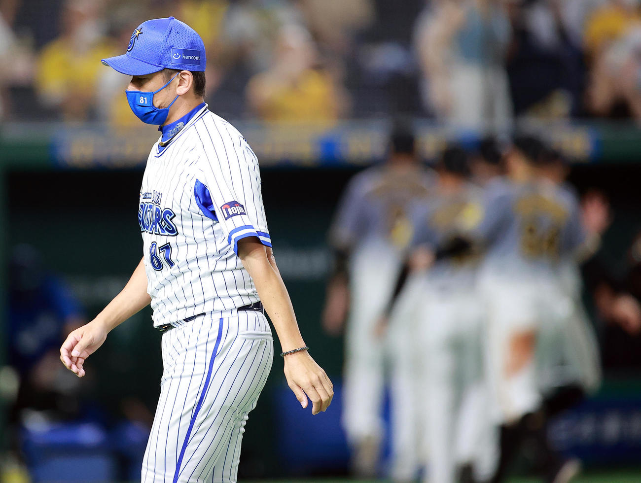 DeNA対阪神　喜ぶ阪神ナインを背にがっくりと引き揚げるDeNA三浦監督（撮影・浅見桂子）