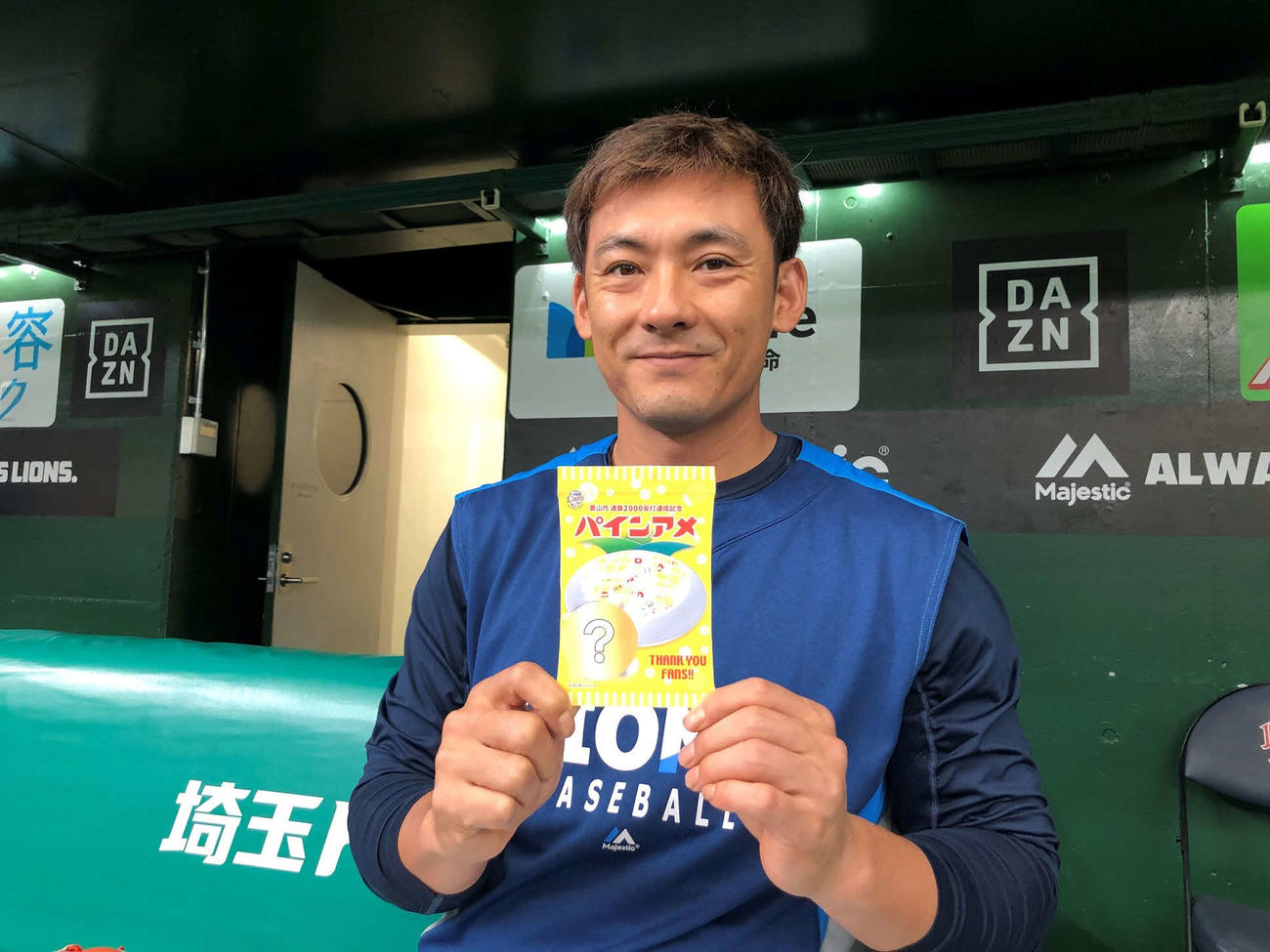 大好きな「パインアメ」を手に笑顔を見せる西武栗山（球団提供）