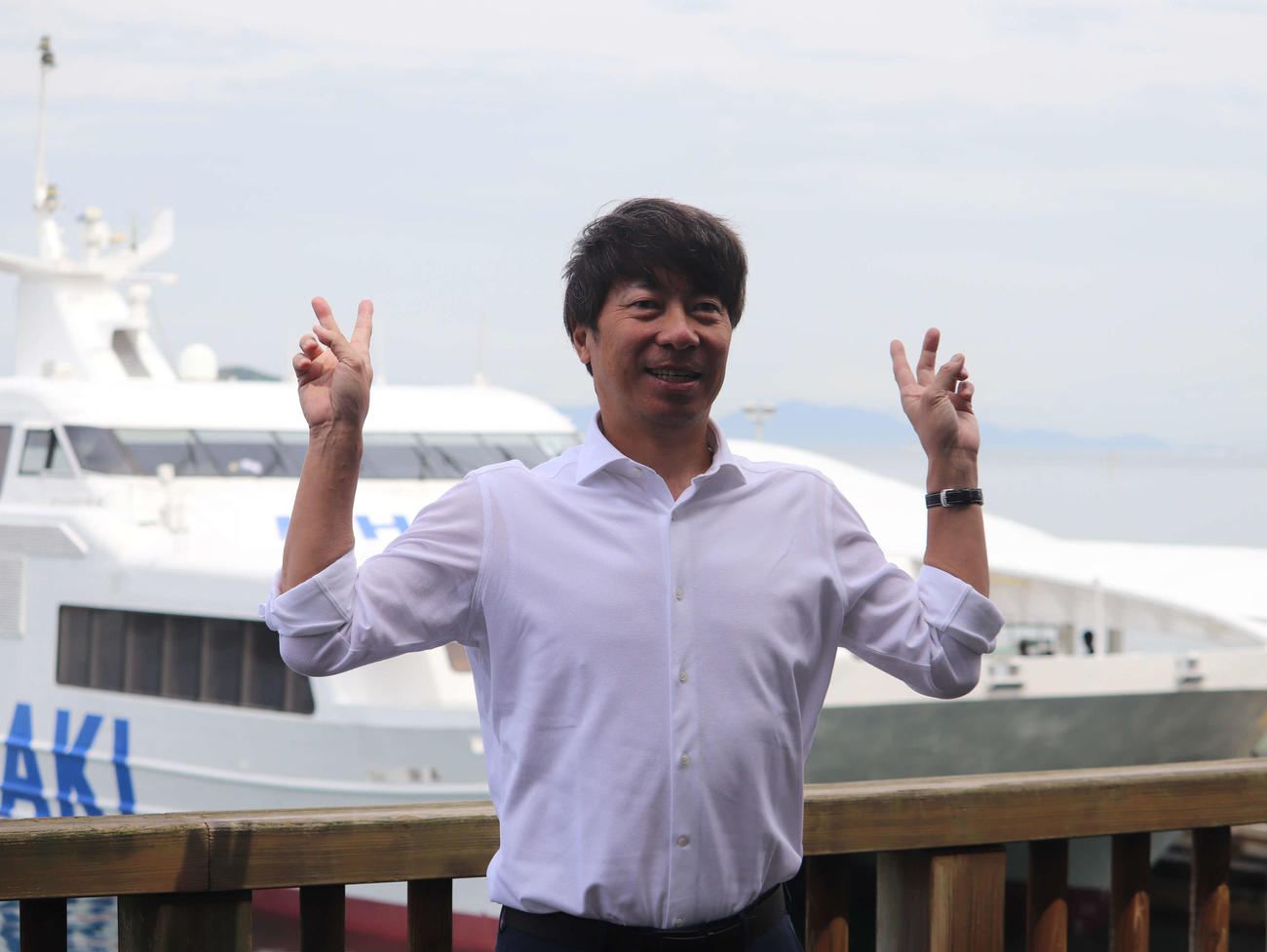 松山から広島への船移動の前に、笑顔で写真に納まるヤクルト高津監督（撮影・湯本勝大）
