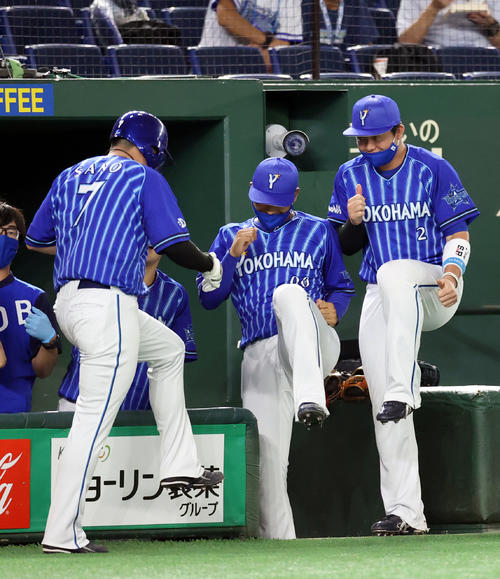 巨人対DeNA 5回表DeNA1死一、三塁、宮崎の犠飛で生還し、宮本（中央）、牧（右）といっしょにダンスする佐野（撮影・狩俣裕三）