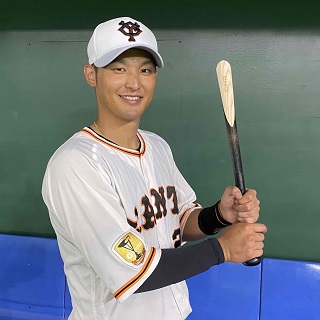 巨人が販売する選手実使用バット靴べらを手に、笑顔を見せる吉川尚輝（球団提供）