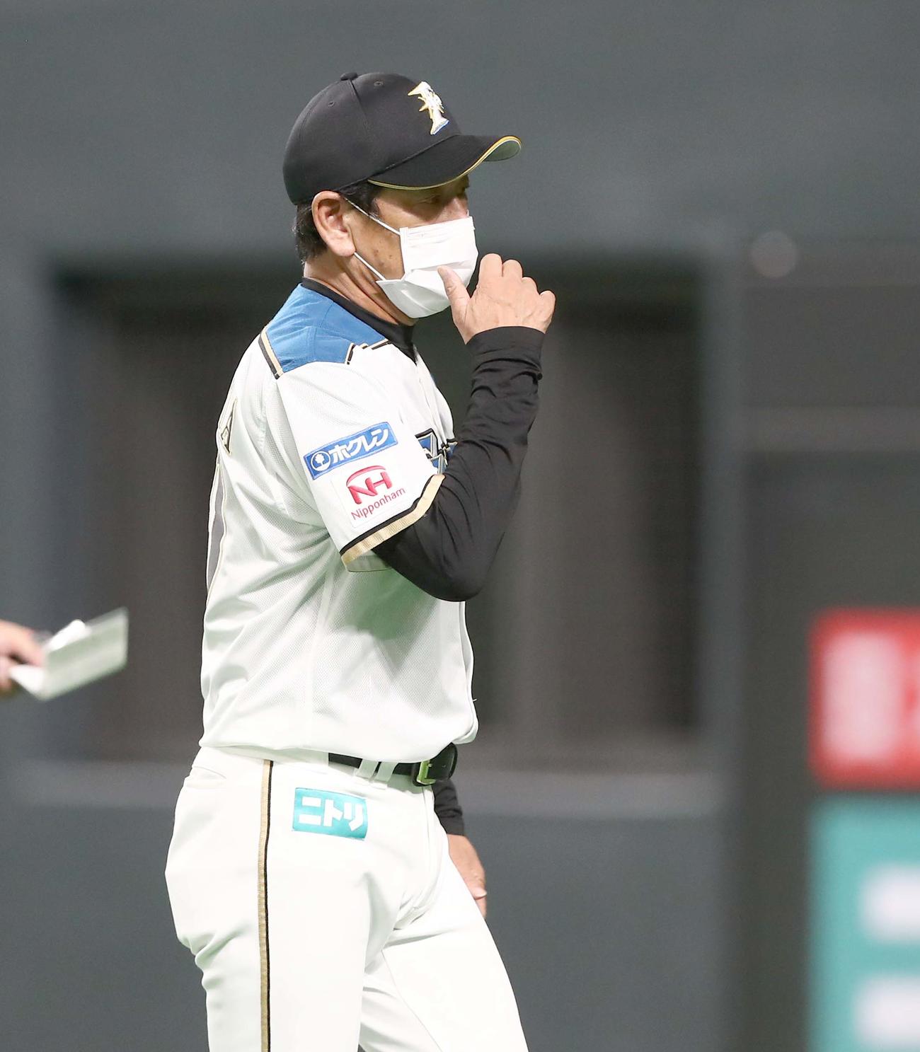 日本ハム対楽天　渋い表情で選手交代を告げる栗山監督（撮影・黒川智章）