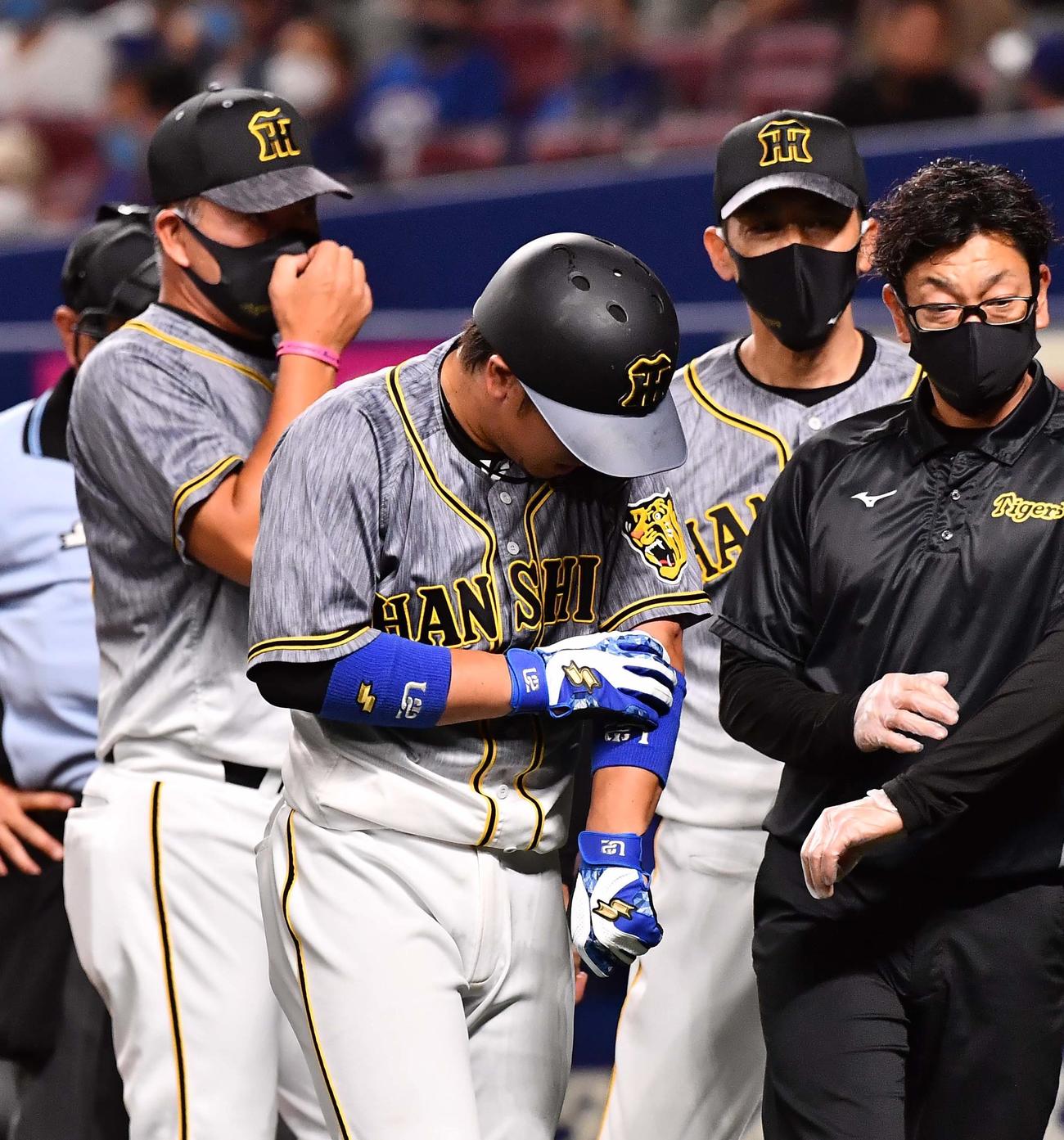 中日対阪神　2回表阪神1死一、三塁、左ヒジに死球を受けた梅野（中央）に心配そうな井上ヘッドコーチ（左）と矢野監督（撮影・上田博志）