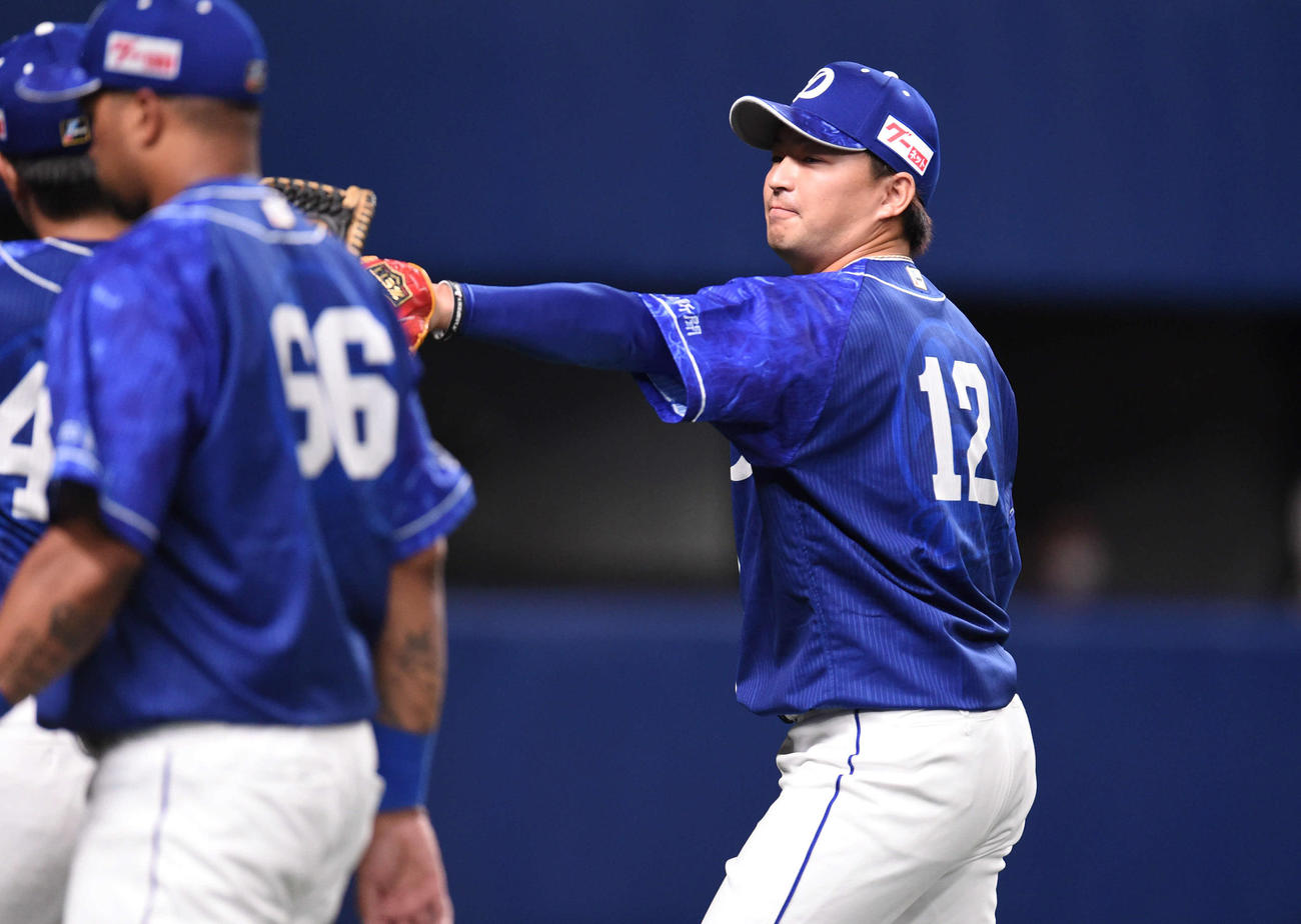 中日対阪神　5回表を抑え、ナインとタッチをかわしベンチへ戻る田島（右）（撮影・森本幸一）