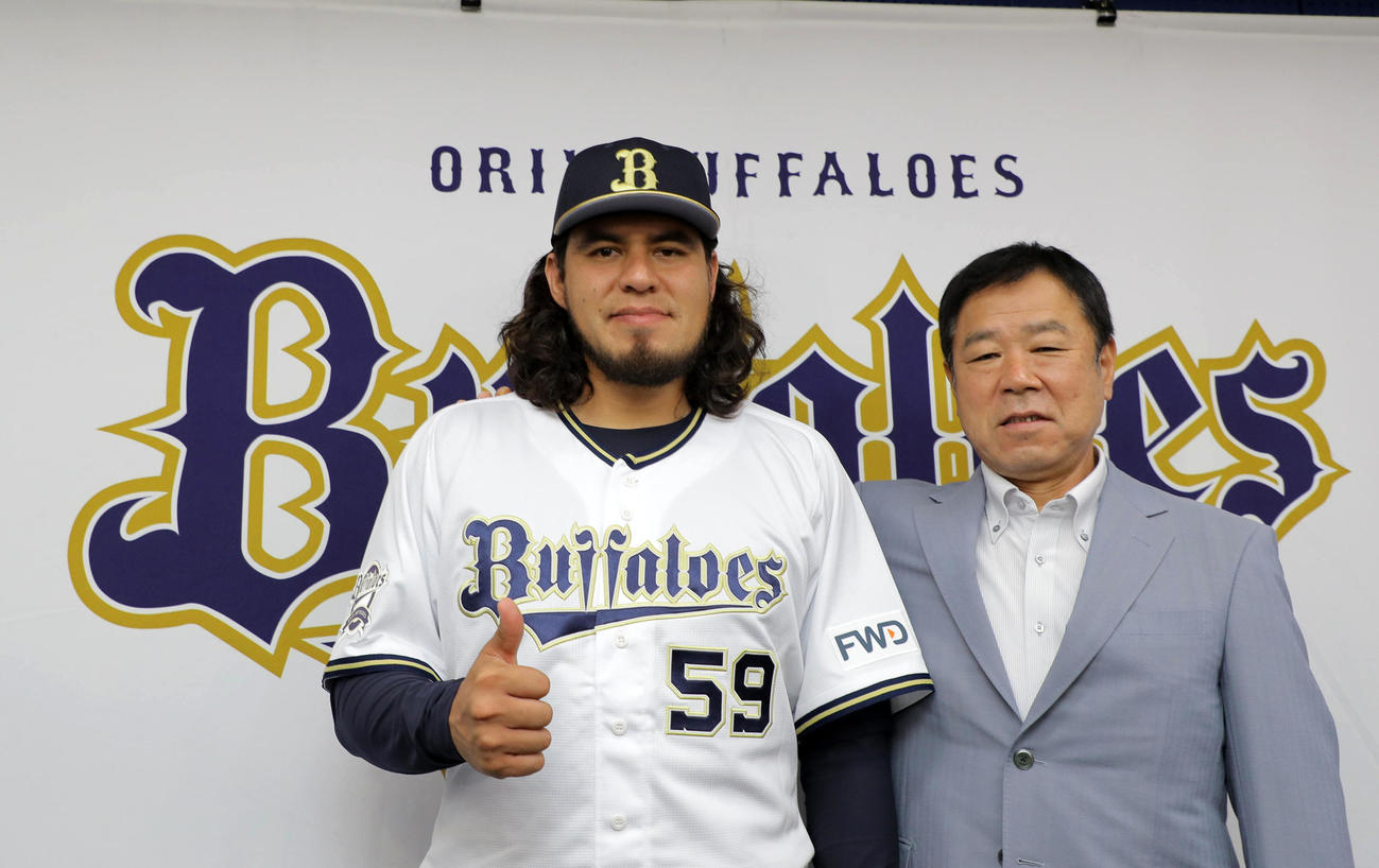 入団発表会見で福良GM（右）から激励を受けるバルガス