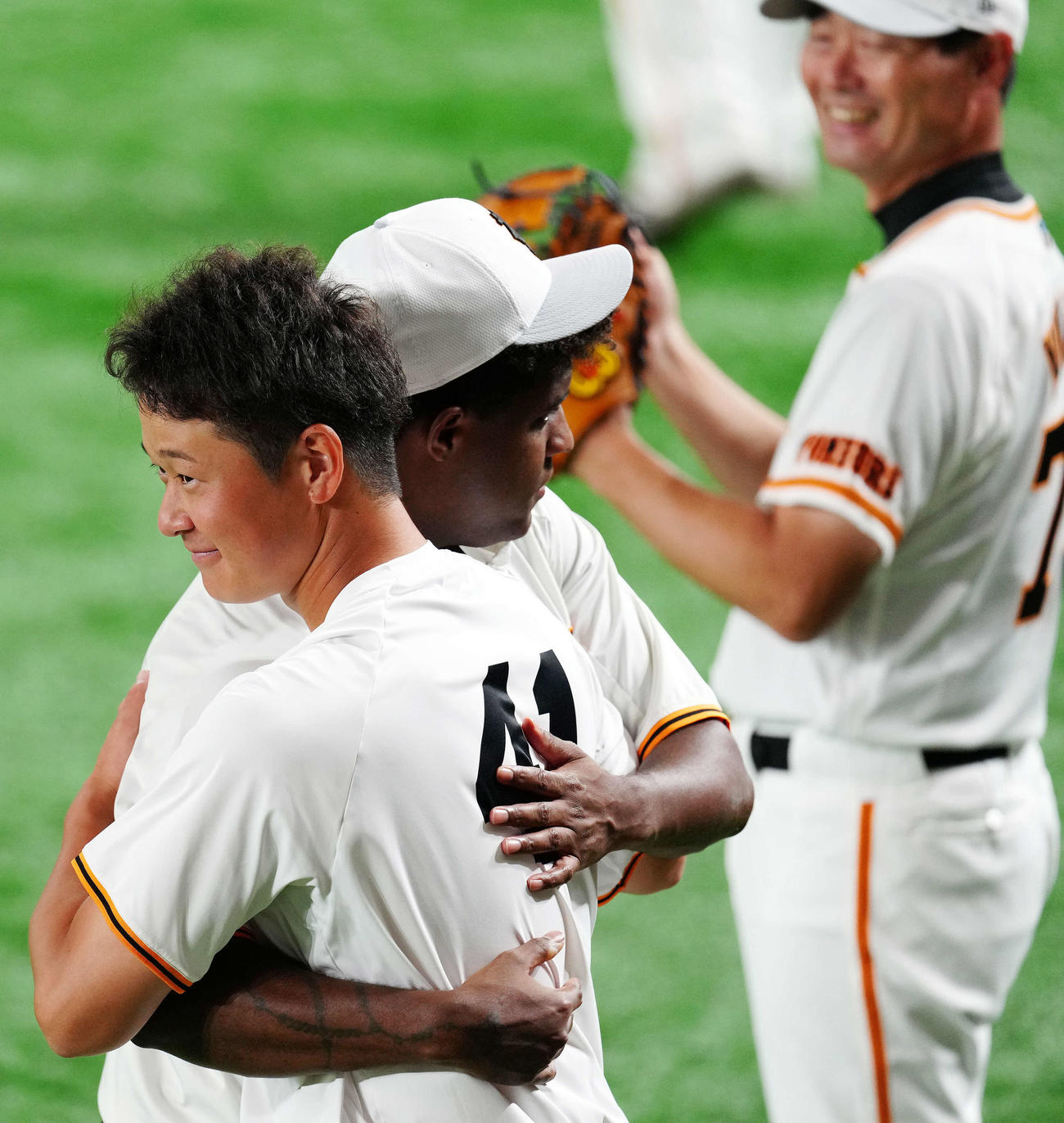 巨人対DeNA　試合前練習中、巨人デラロサ（左）と抱き合う中川。後方は桑田投手チーフコーチ補佐（撮影・江口和貴）