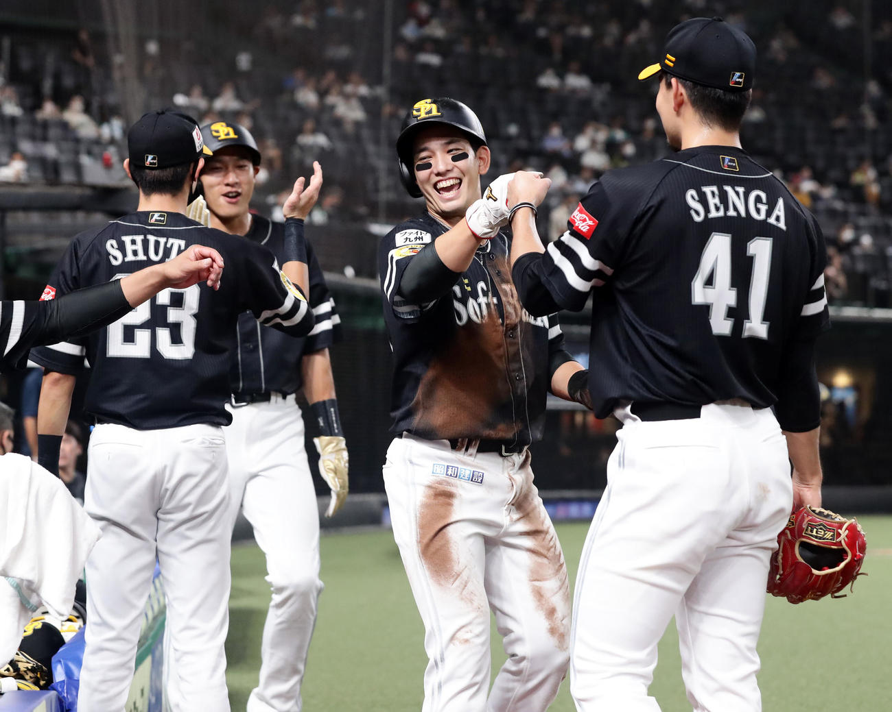 西武対ソフトバンク　3回表ソフトバンク1死二、三塁、デスパイネの中前適時打で生還した栗原（中央）は笑顔で千賀らナインとハイタッチ（撮影・浅見桂子）