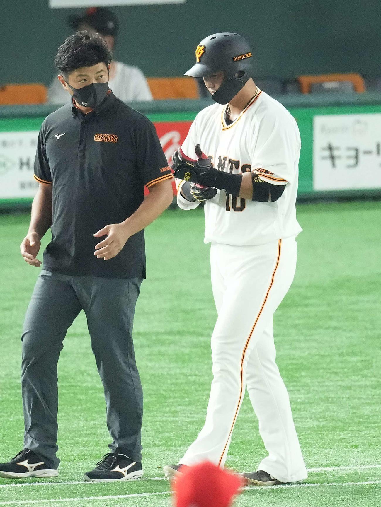 巨人対広島　6回裏巨人無死、死球を受けた中田（右）は手を気にしながら一塁へ向かう（撮影・鈴木みどり）