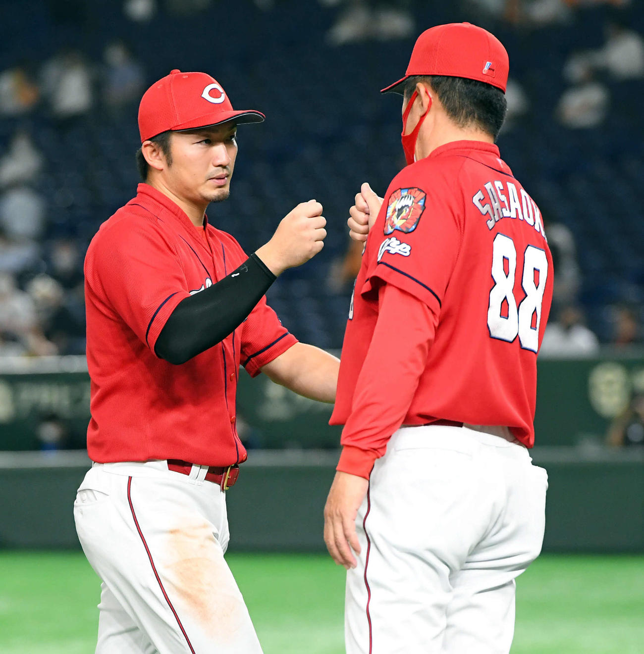 巨人対広島　巨人に勝利し佐々岡監督（右）とハイタッチする広島鈴木誠（撮影・たえ見朱実）