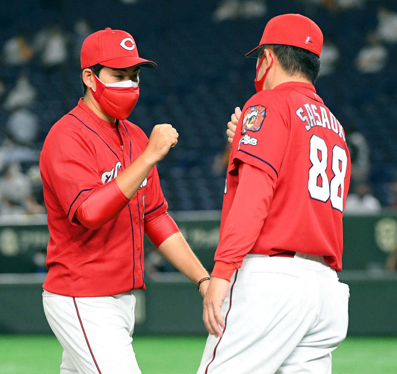 巨人対広島　巨人に勝利し佐々岡監督（右）とハイタッチする広島九里（撮影・たえ見朱実）