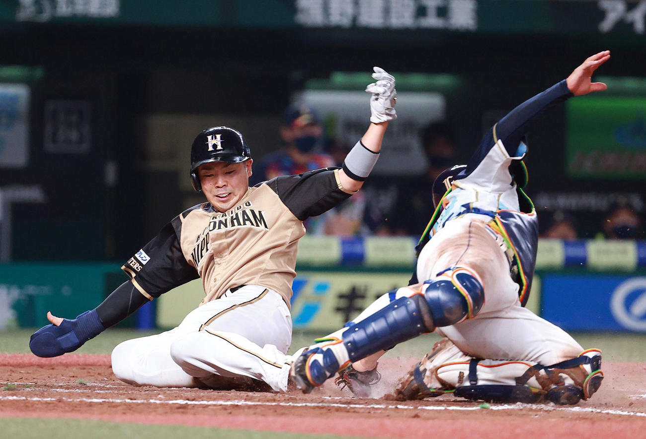 西武対日本ハム　7回表日本ハム1死二、三塁、木村の右犠飛で生還する近藤（左）。捕手柘植（撮影・浅見桂子）