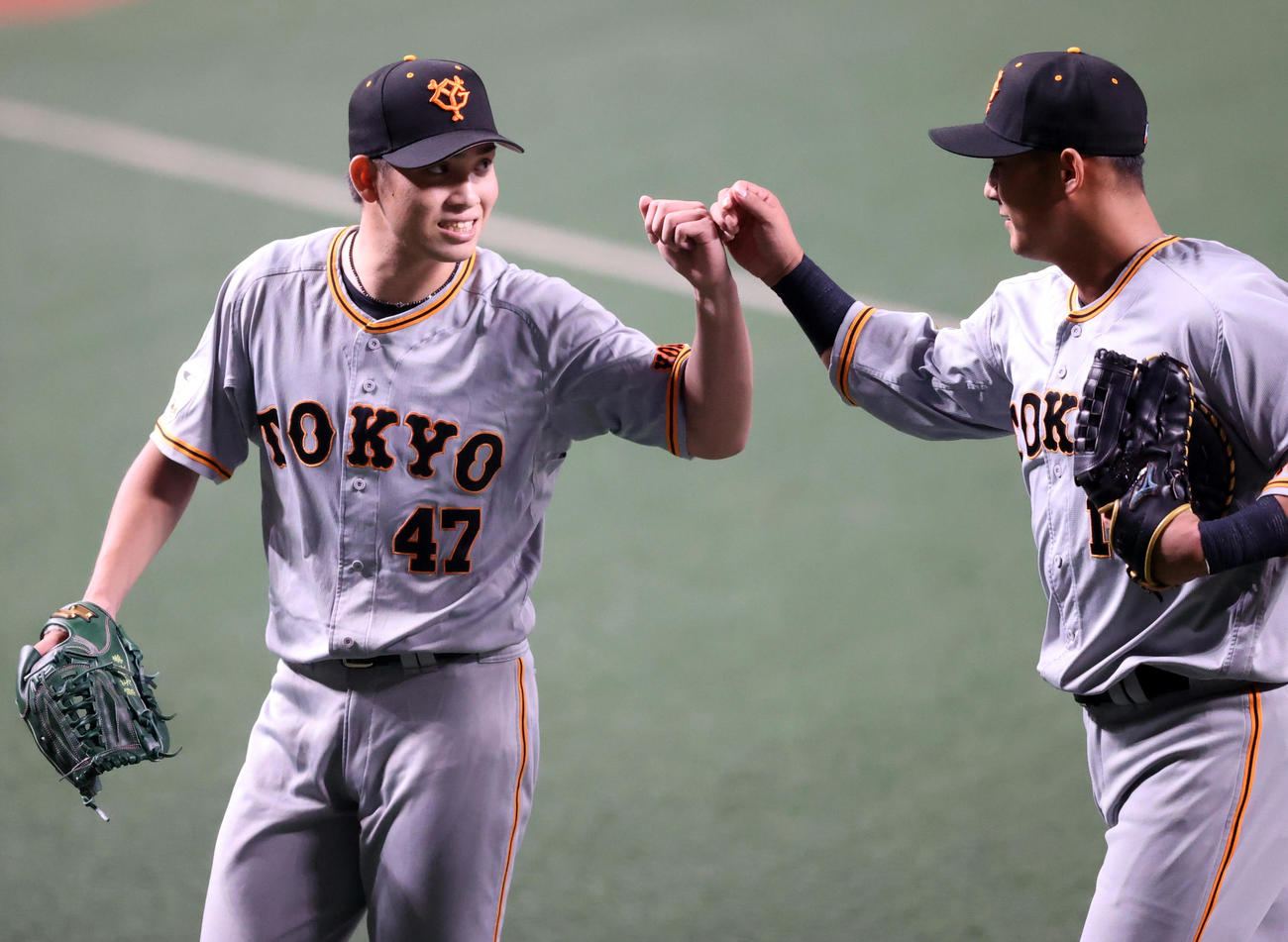中日対巨人　1回裏を抑え、中田（右）とタッチを交わす先発の高橋（撮影・狩俣裕三）