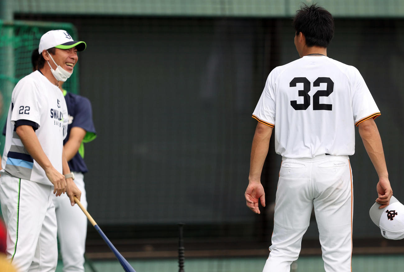 巨人対ヤクルト　試合前、広岡（右）と談笑する高津監督（撮影・狩俣裕三）