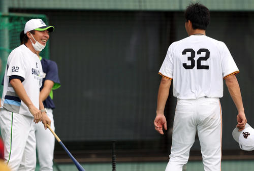 巨人対ヤクルト 試合前、広岡(右)と談笑する高津監督(撮影・狩俣裕三)