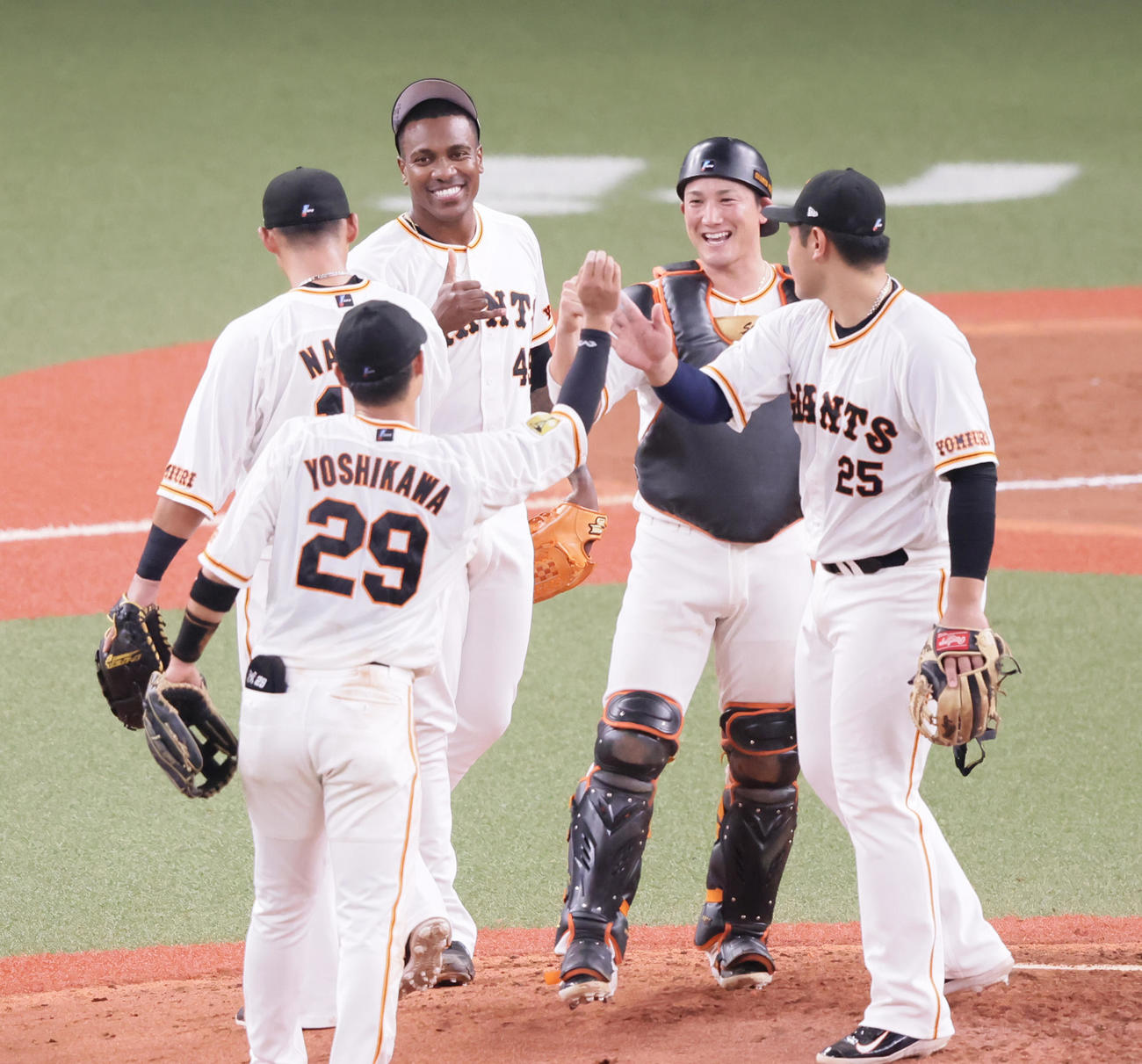 巨人対ヤクルト　9回から登板し、32試合連続無失点を飾った巨人ビエイラ（後方左から2人目）は笑顔でタッチを交わす（撮影・足立雅史）