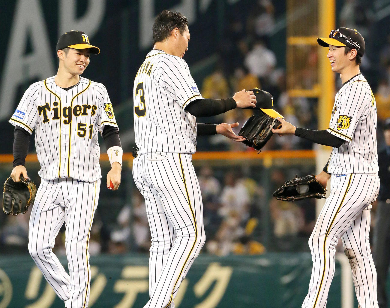 阪神対中日　6回に右前適時打を放った大山（中央）にグラブを渡し笑顔を見せる近本、左は中野（撮影・上山淳一）