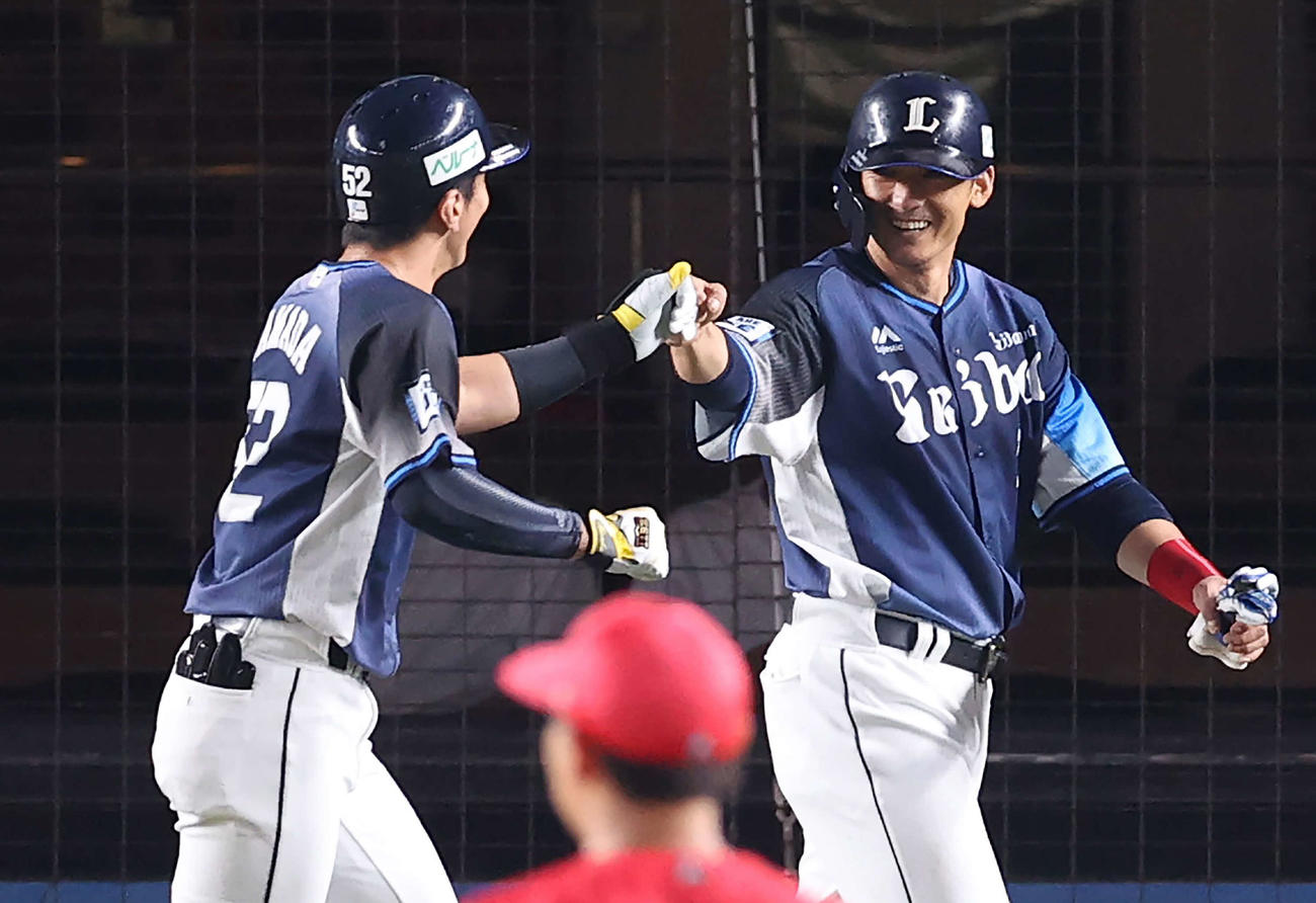 1日、ロッテ戦の6回に山田（左）の犠飛で生還し笑顔を見せる西武栗山