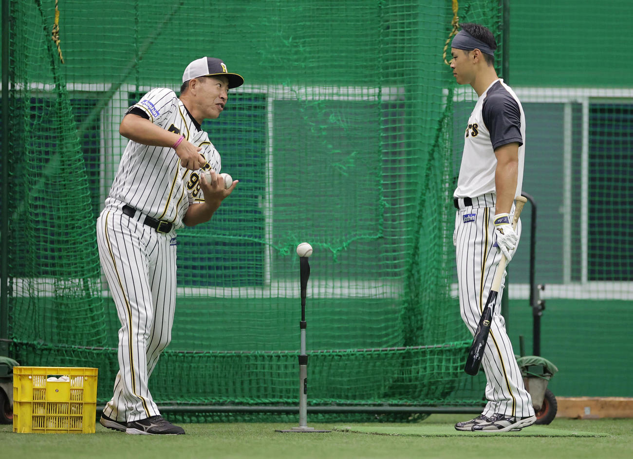 井上ヘッドコーチ（左）から打撃指導を受ける佐藤輝（撮影・清水貴仁）