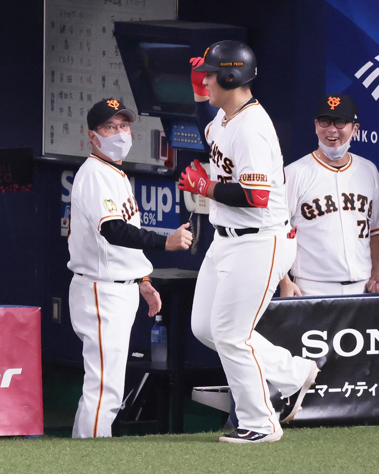 巨人対ヤクルト　2回裏巨人無死、左越え本塁打を放った岡本和（中央）を迎える原監督（左）と元木コーチ（撮影・足立雅史）
