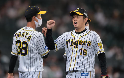 阪神対巨人　3回表を投げ終え、ナインとグータッチを交わしてベンチへ戻る阪神西勇（右）（撮影・前田充）