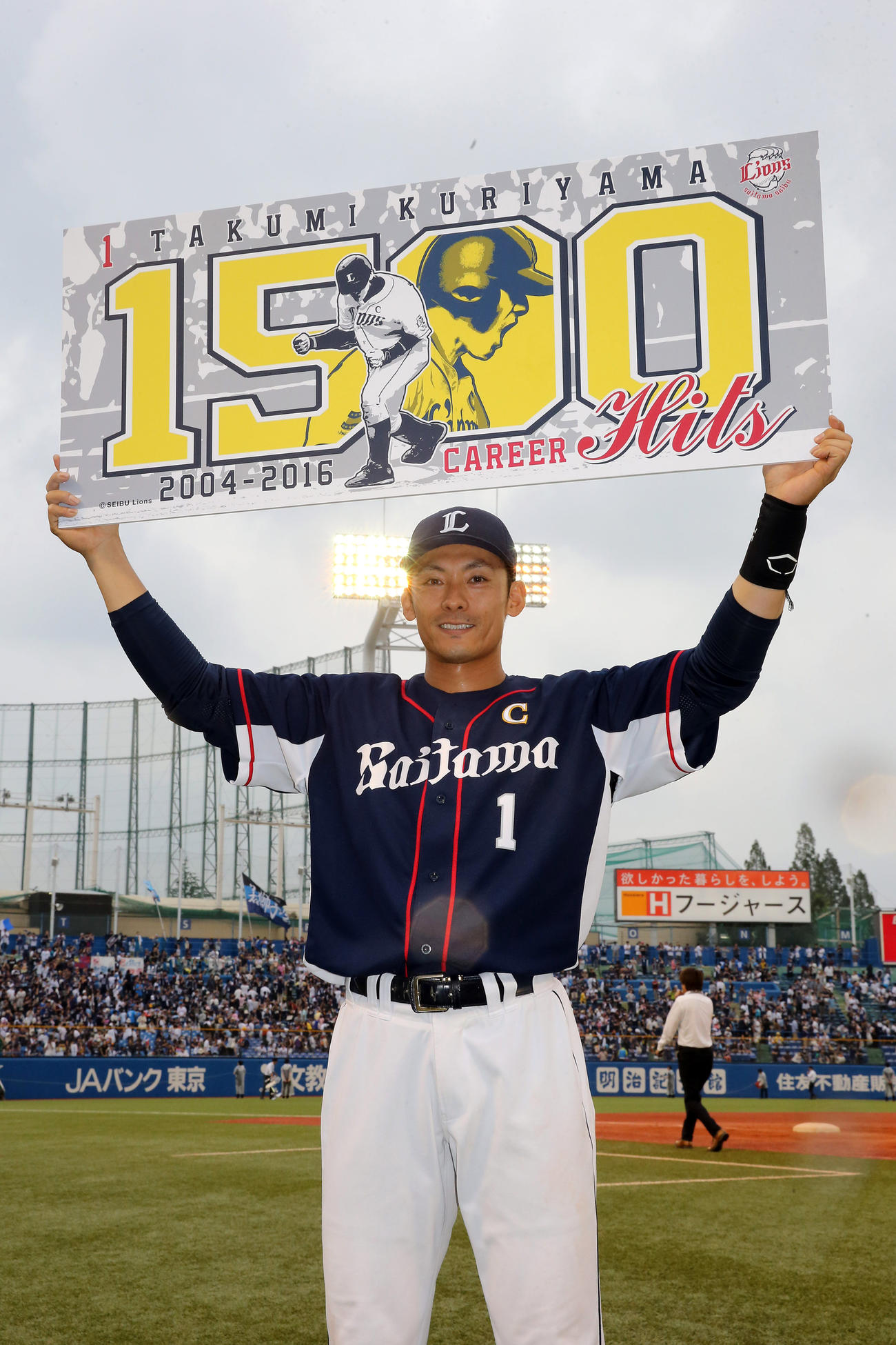 16年6月、ヤクルトとの交流戦でプロ通算1500安打を達成して記念ボードを手に笑顔を見せる西武栗山