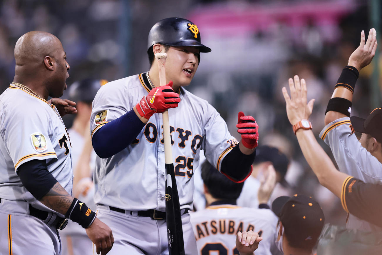 阪神対巨人　6回表巨人1死三塁、岡本和は左越え2点本塁打を放ち笑顔でタッチを交わす（撮影・足立雅史）
