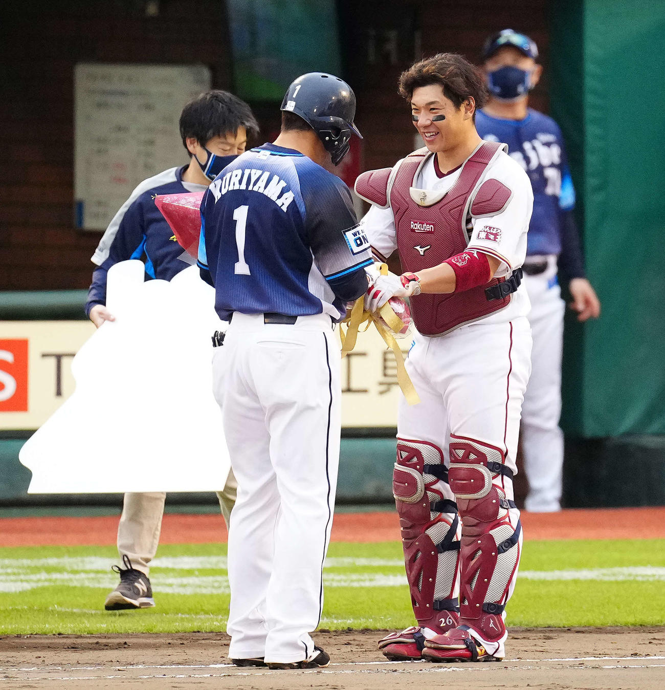 楽天対西武　9回表、通算2000安打を達成した西武栗山（中央）に花束を手渡す楽天炭谷（撮影・江口和貴）
