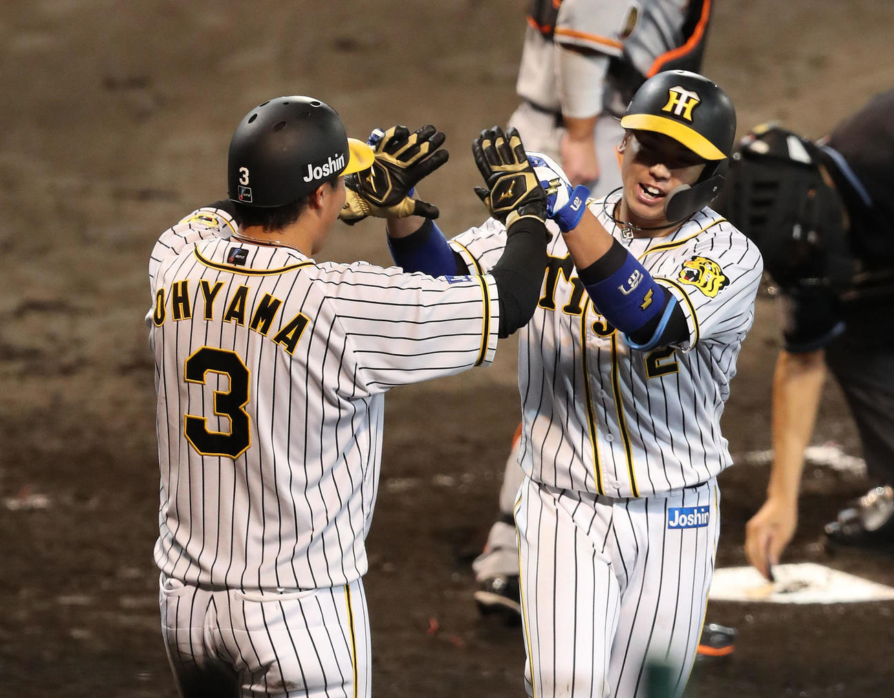 阪神対巨人　5回裏阪神1死一塁、左越え2点本塁打を放った梅野（右）は大山とタッチを交わす（撮影・白石智彦）