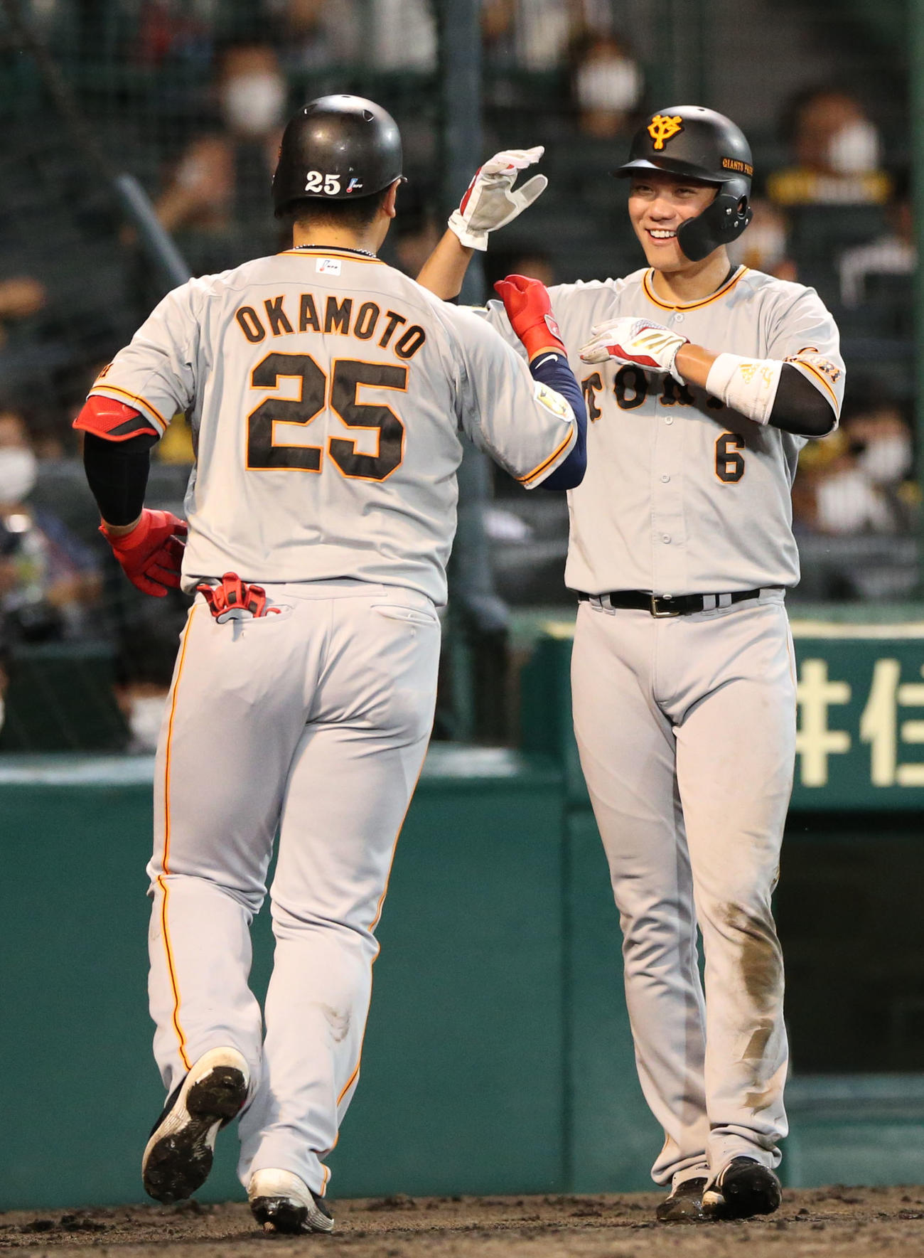 阪神対巨人　6回表巨人1死三塁、岡本和（手前）は左越え2点本塁打を放ち生還し、坂本の出迎えを受ける（撮影・上山淳一）