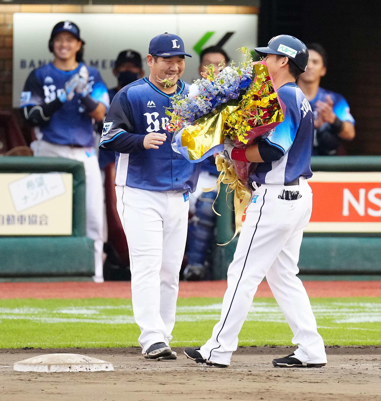 楽天対西武　9回表、通算2000安打を達成した西武栗山（右）に花束を手渡した中村（撮影・江口和貴）