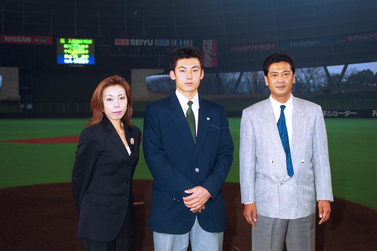 01年12月、新入団選手発表時に母寿江さん、父忠人さんと写真に納まる栗山（中央）