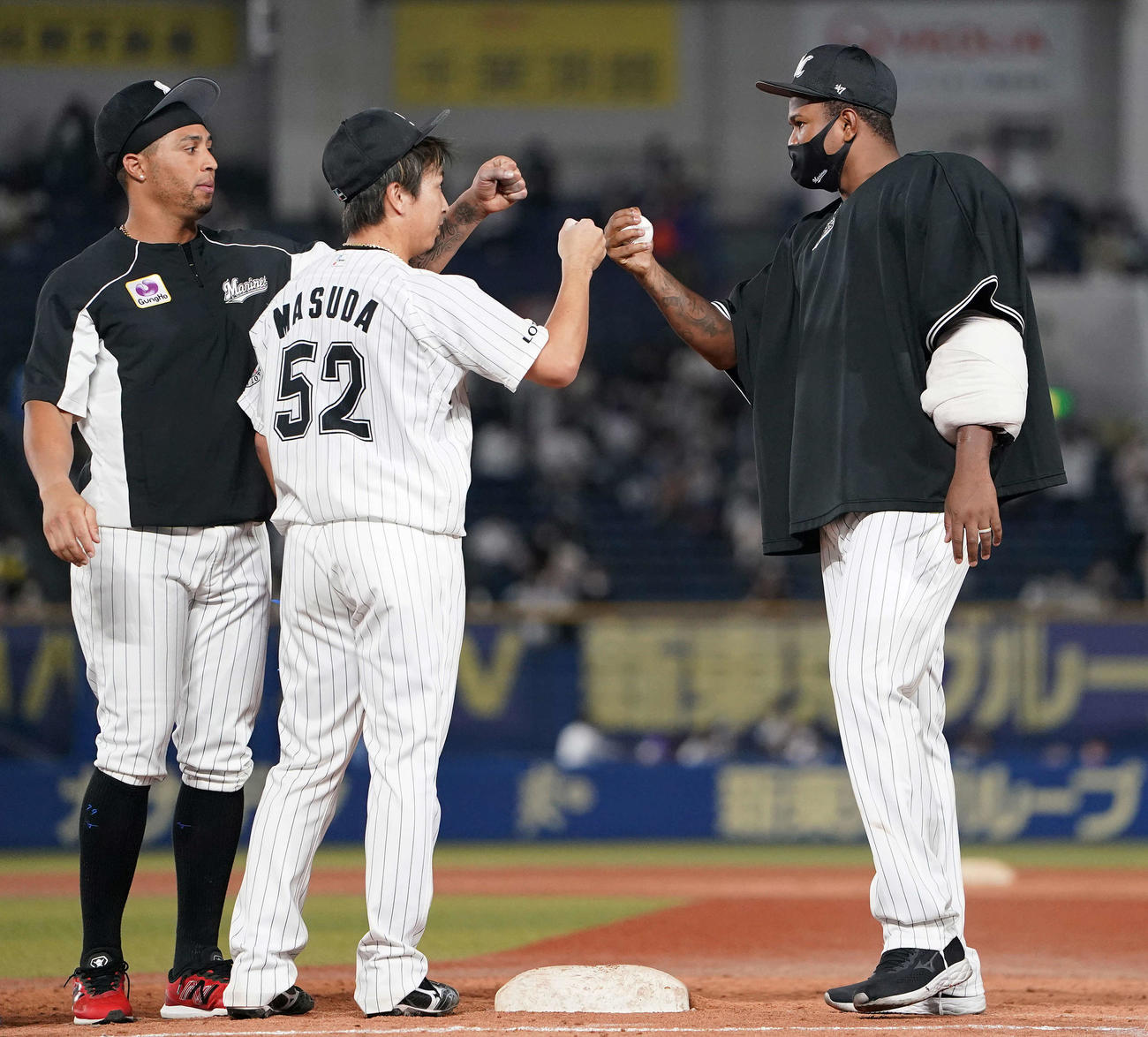 ロッテ対日本ハム　日本ハムに勝利し、移籍後初勝利のロッテ・ロメロ（右）は益田（中央）、マーティンとタッチを交わす（撮影・鈴木みどり）