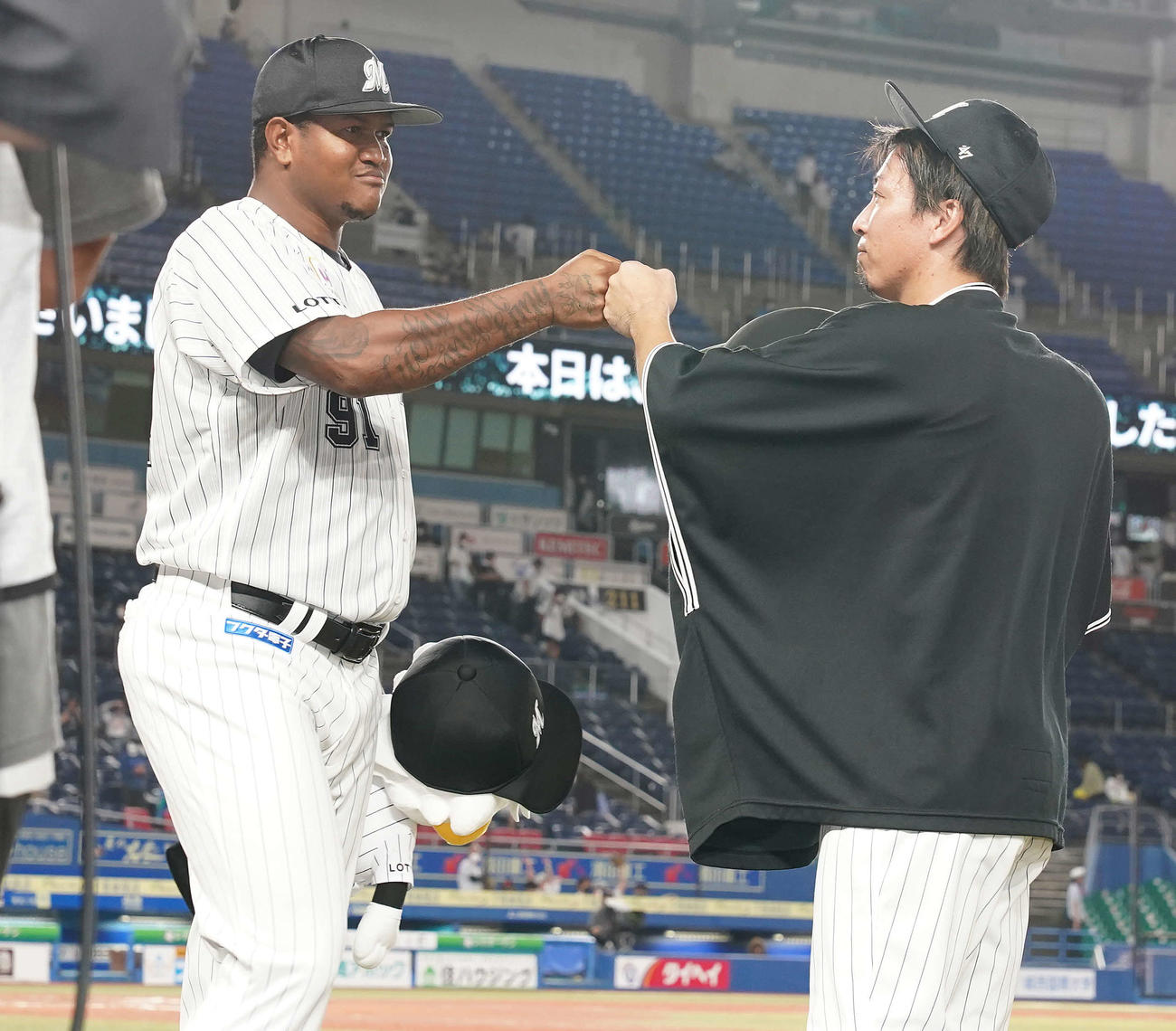ロッテ対日本ハム　日本ハムに勝利し、タッチを交わすロッテ・ロメロ（左）と益田（撮影・鈴木みどり）