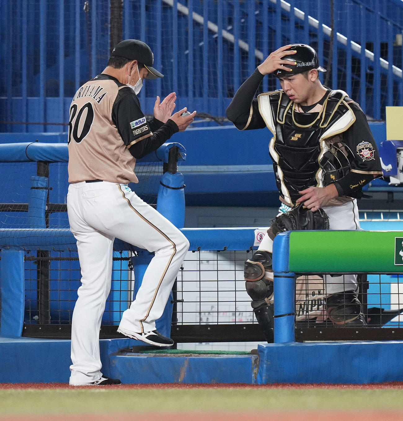 ロッテ対日本ハム　8回裏の投手交代を告げ、選手を鼓舞しながらベンチへ戻る日本ハム栗山監督（左）（撮影・鈴木みどり）