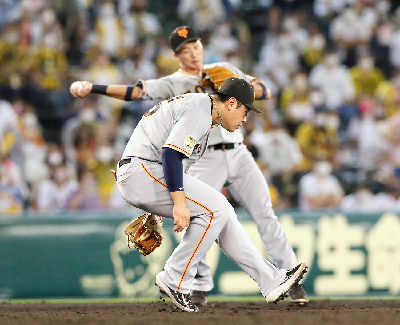 阪神対巨人　7回裏阪神無死一塁、マルテの遊ゴロを二塁に悪送球する遊撃手広岡、手前は三塁手岡本和（撮影・上山淳一）