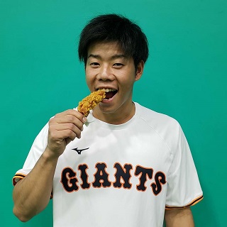 特別メニュー「クリスピーチキン：ジャイアンツわっしょい！！ボックス」を笑顔で試食する巨人松原（球団提供）