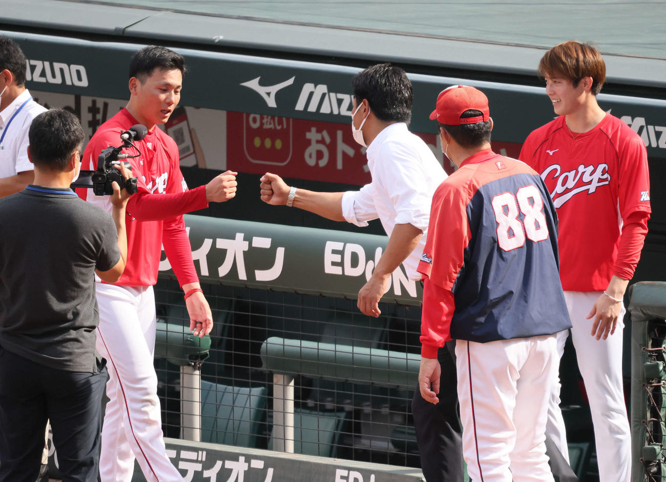 広島対中日　日本代表の稲葉監督とグータッチする栗林。右から2人目は佐々岡監督。右は森下（撮影・加藤孝規）